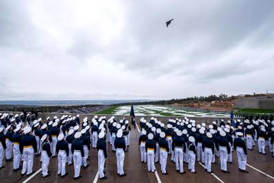 U.S. Air Force Academy cadets admire a B-2 Spirit bomber as it flies over Stillman Field for the Class of 2022 graduation parade on May 24, 2022, in Colorado Springs, Colo. (Trevor Cokley/Air Force)