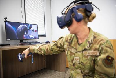 Air Force Staff Sgt. Renee Scherf, Detachment 23 curriculum engineer and MC-130H subject matter expert, demonstrates a virtual reality training system. Detachment 23’s Tech Training Transformation uses tools like virtual reality training systems and artificial intelligence to transform airman education. (Staff Sgt. Keith James/Air Force)