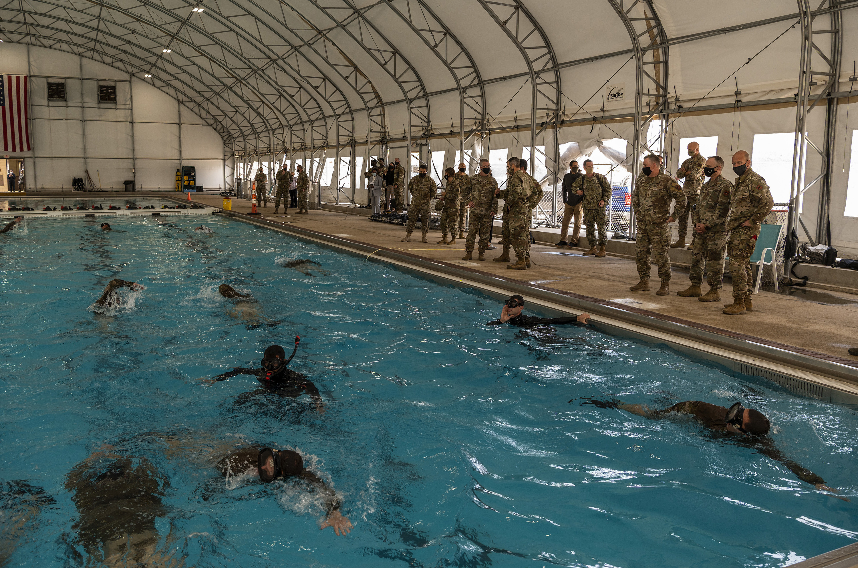 Army Gen. Richard D. Clarke, commander of U.S. Special Operations Command, at MacDill Air Force Base, Fla. and U.S. Air Force Chief Master Sgt. Gregory Smith, USSOCOM command chief (both center-right), listen to a brief during a tour of the Special Warfare Training Wing's water confidence drill Oct. 16, 2020, at Joint Base San Antonio-Lackland, Texas. (Johnny Saldivar/Air Force)