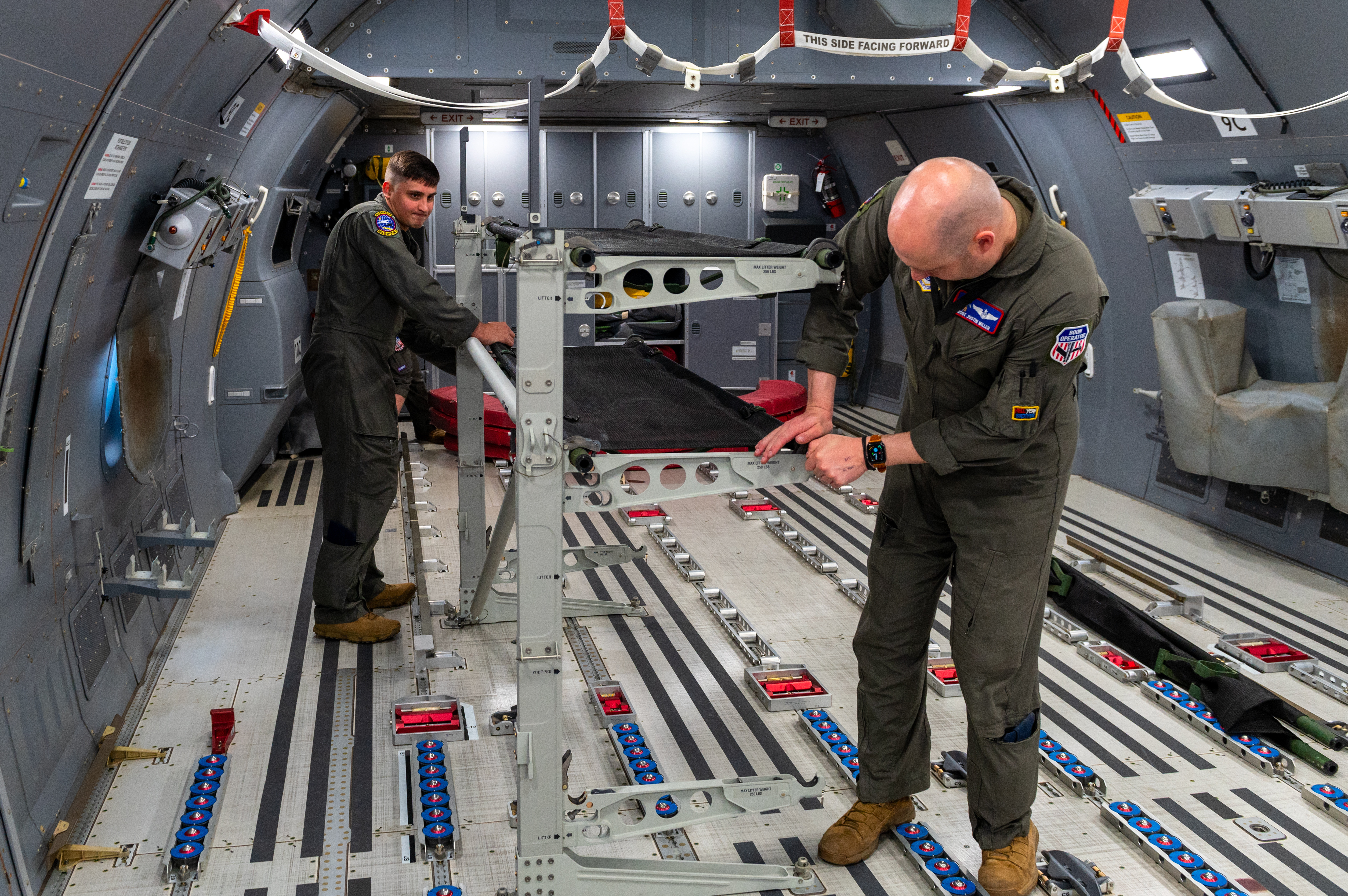 Staff Sgt. Jonathan Sanders and Master Sgt. Justin Miller, 349th Air Refueling Squadron boom operators, set up palletized cots in the back of a KC-46A Pegasus May 5, 2022. (Airman Brenden Beezley/Air Force)