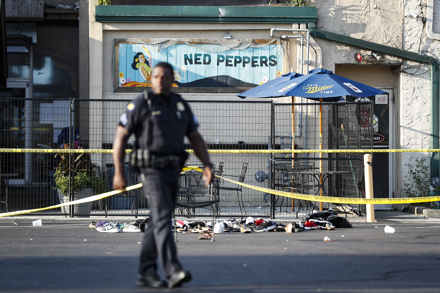 Shoes are piled outside the scene of a mass shooting including Ned Peppers bar, Sunday, Aug. 4, 2019, in Dayton, Ohio.